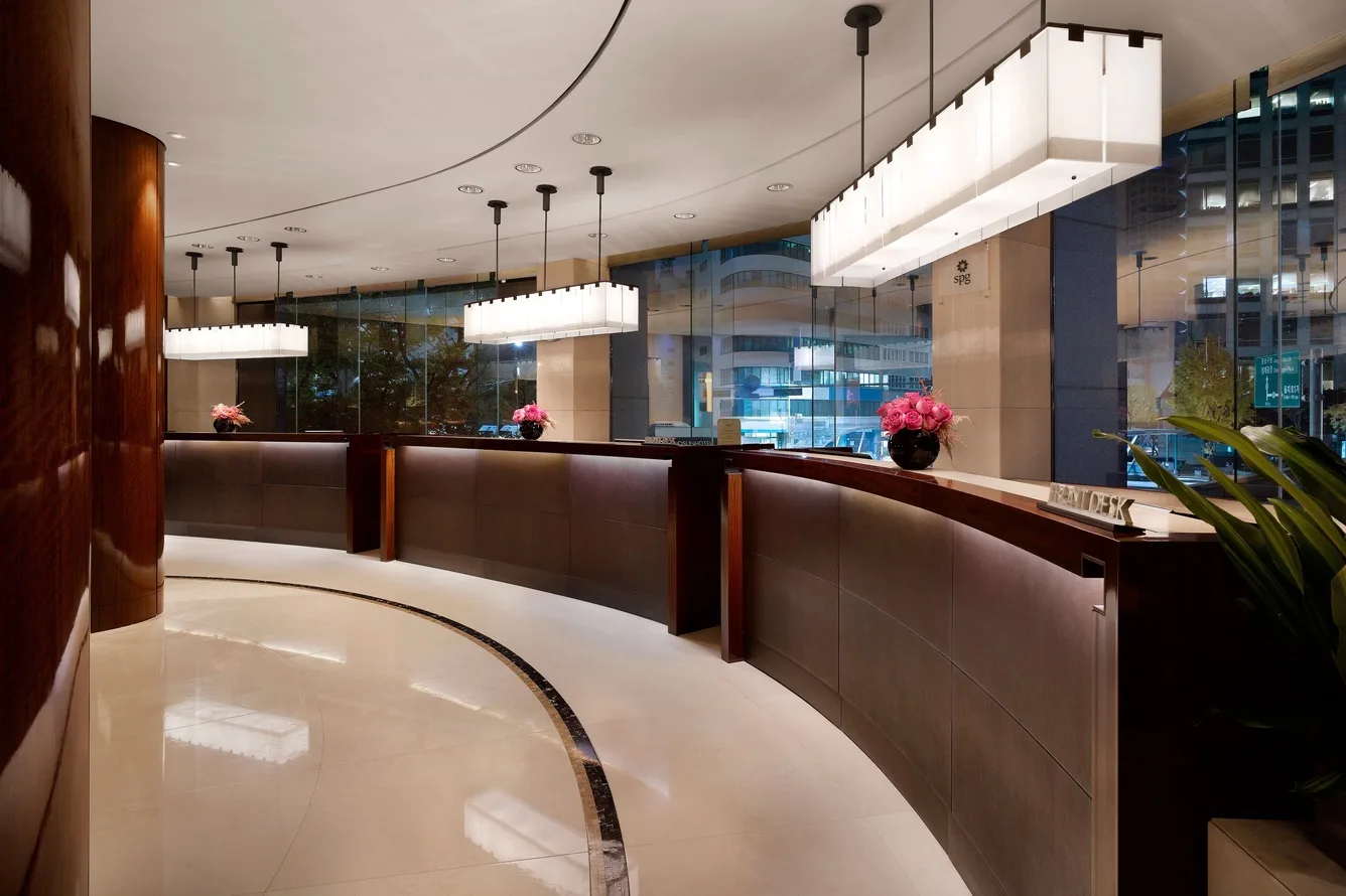 A row of illuminated wooden front desks inside The Westin Josun Seoul