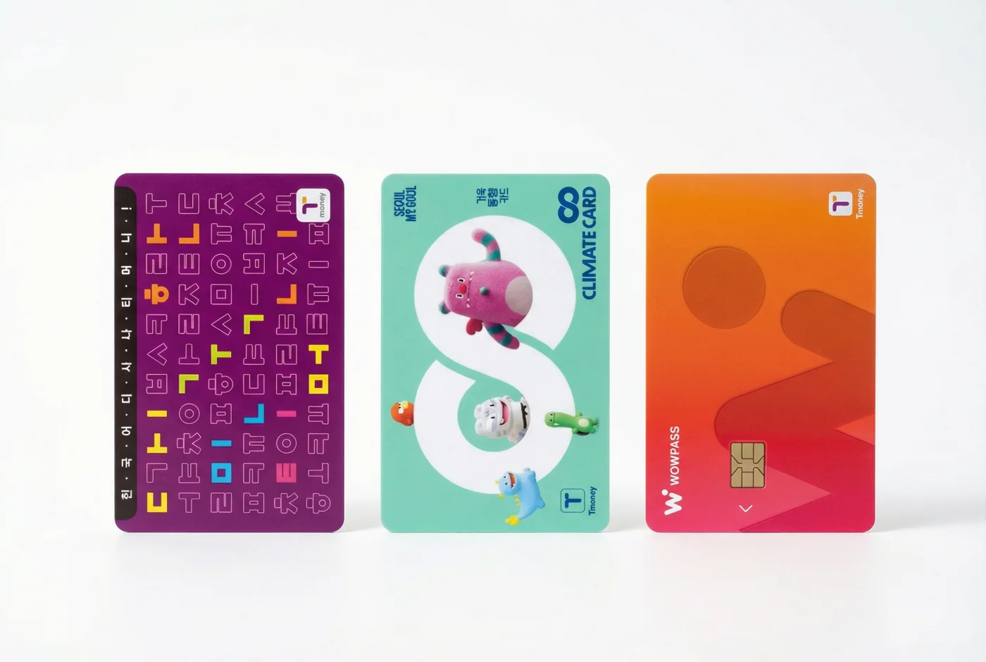 Three Korean travel cards standing side by side: a Tmoney card, a Climate Card, and a WOWPASS card